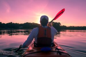 Man kayaking during sunset